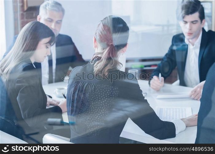 Business colleagues meeting in conference room, shot through glass