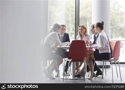 Business colleagues planning while sitting at table during meeting in office