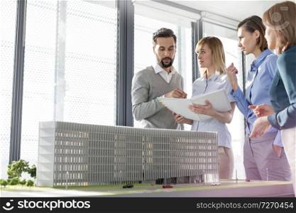 Business colleagues reading document while planning over project in office
