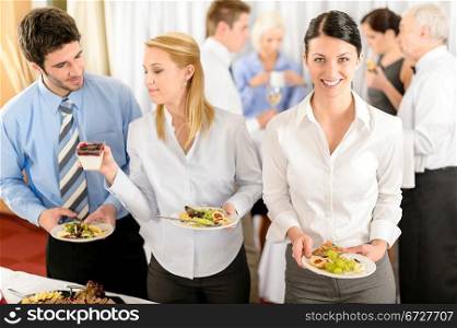 Business colleagues serve themselves at buffet catering service company event