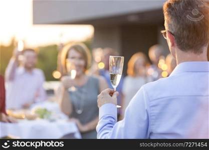 Business colleagues toasting wineglasses during rooftop success party
