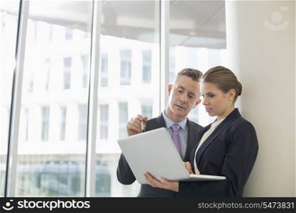 Business colleagues using laptop in office