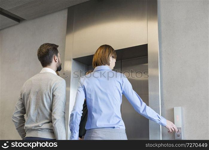 Business colleagues waiting for elevator at corporate office