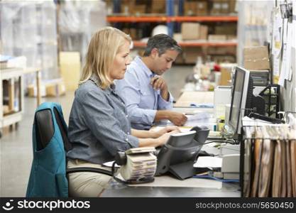 Business Colleagues Working At Desk In Warehouse