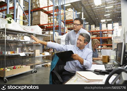 Business Colleagues Working At Desk In Warehouse