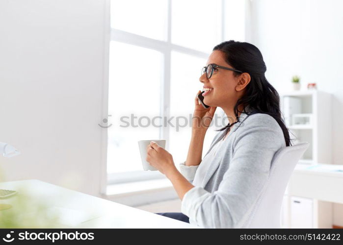 business, communication and people concept - happy businesswoman or secretary calling on smartphone and drinking coffee at office. businesswoman calling on smartphone at office