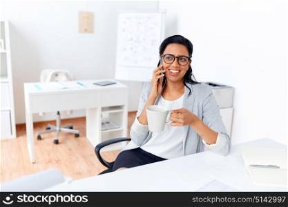 business, communication and people concept - happy businesswoman or secretary calling on smartphone and drinking coffee at office. businesswoman calling on smartphone at office