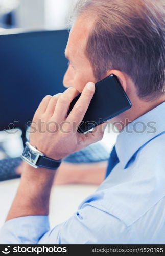 business, communication and technology concept- businessman with smartphone in office