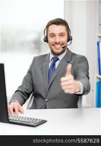 business, communication and technology concept - friendly male helpline operator with headphones and computer at call center showing thumbs up
