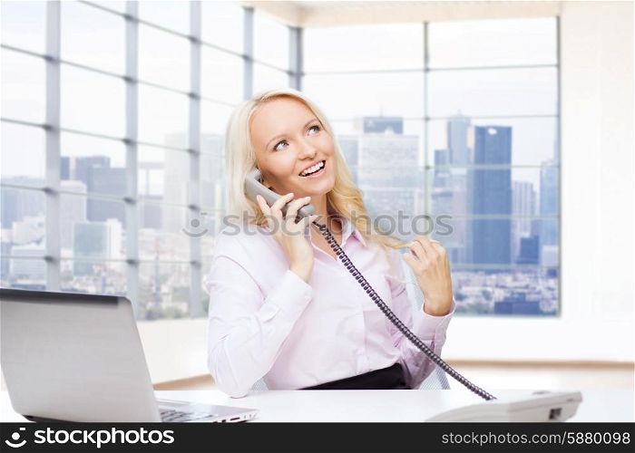 business, communication, people and technology concept - smiling businesswoman or secretary with laptop computer calling on telephone over office room with city view window background