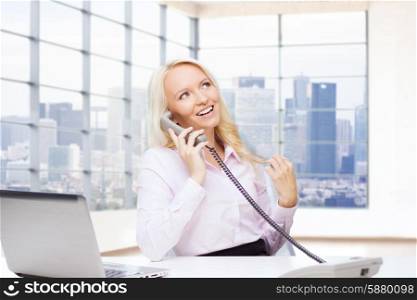 business, communication, people and technology concept - smiling businesswoman or secretary with laptop computer calling on telephone over office room with city view window background