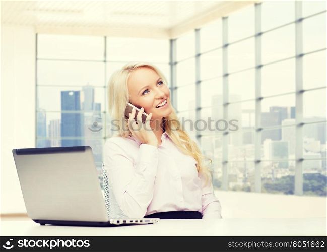business, communication, people and technology concept - smiling businesswoman or secretary with laptop computer calling on smartphone over office room with city view window background
