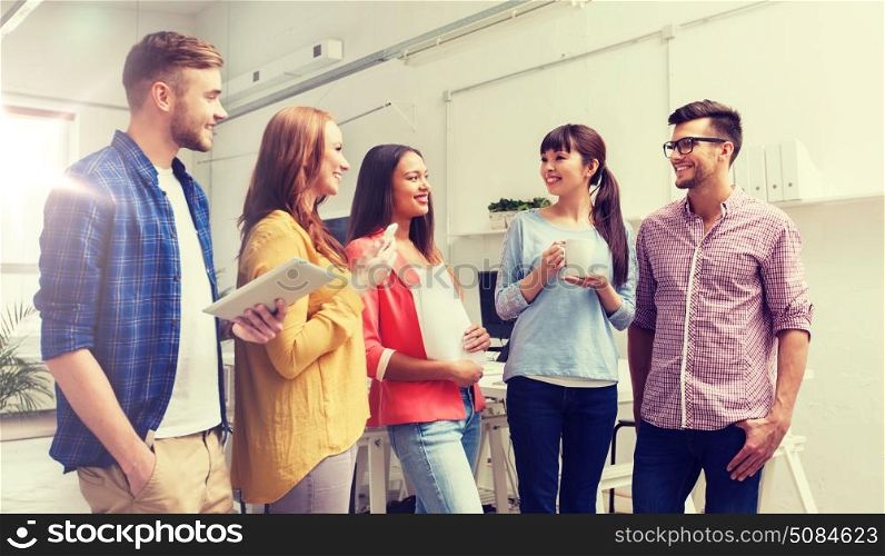 business, communication, startup and people concept - happy international creative team or students on coffee break talking at office. creative team on coffee break talking at office. creative team on coffee break talking at office
