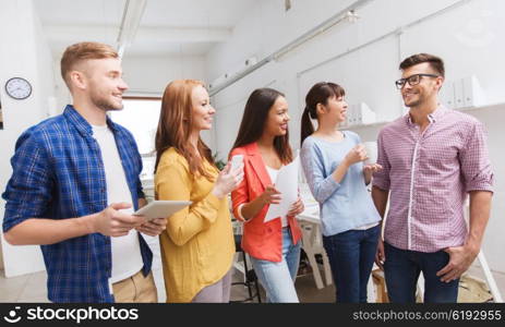 business, communication, startup and people concept - happy international creative team or students on coffee break talking at office