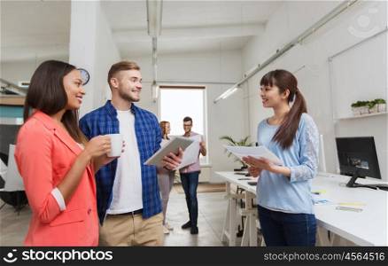 business, communication, startup and people concept - happy multiracial creative team or students with tablet pc and papers on coffee break talking at office