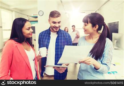 business, communication, startup and people concept - happy multiracial creative team or students with tablet pc and papers on coffee break talking at office. creative team with tablet pc and papers at office