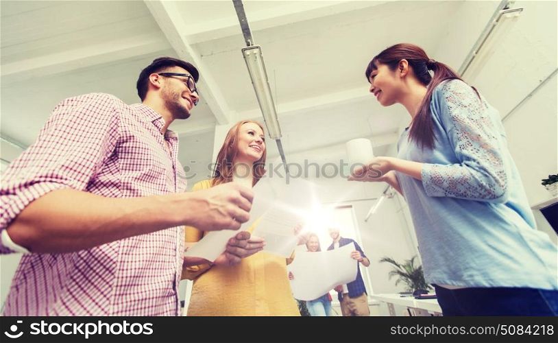business, communication, startup and people concept - happy multiracial creative team or students on coffee break talking at office. creative team on coffee break talking at office. creative team on coffee break talking at office