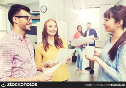 business, communication, startup and people concept - happy multiracial creative team or students on coffee break talking at office. creative team on coffee break talking at office. creative team on coffee break talking at office