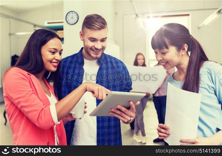 business, communication, startup and people concept - happy multiracial creative team or students with tablet pc computer and papers on coffee break talking at office. creative team with tablet pc and papers at office