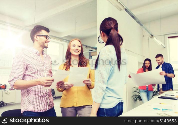 business, communication, startup and people concept - happy multiracial creative team or students on coffee break talking at office. creative team on coffee break talking at office