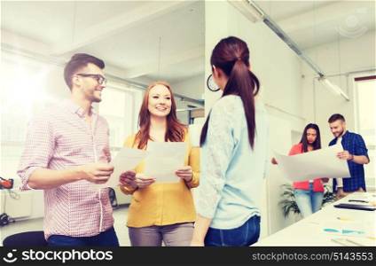 business, communication, startup and people concept - happy multiracial creative team or students on coffee break talking at office. creative team on coffee break talking at office