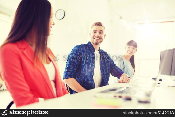 business, communication, startup and people concept - happy multiracial creative team talking at office. happy international creative team at office