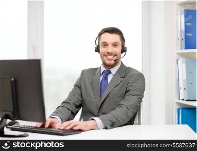 business, communication, technology and call center concept - friendly male helpline operator with headphones and computer at call center