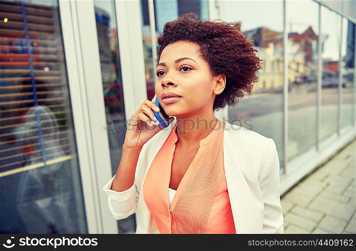 business, communication, technology and people concept - young african american businesswoman calling on smartphone in city