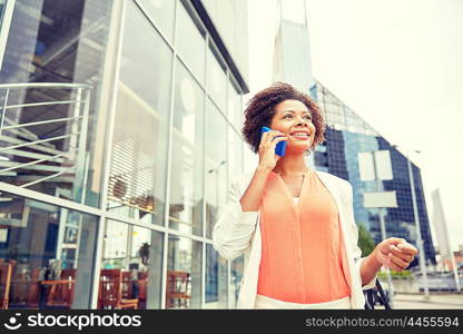 business, communication, technology and people concept - young smiling african american businesswoman calling on smartphone in city