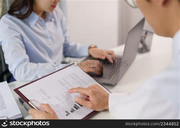 Business concept, Business colleague pointing on document to explain financial data to partner.
