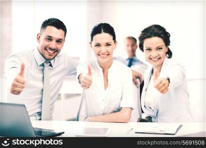 business concept - business team showing thumbs up in office