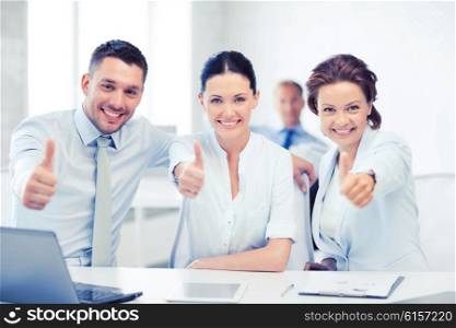 business concept - business team showing thumbs up in office. business team showing thumbs up in office