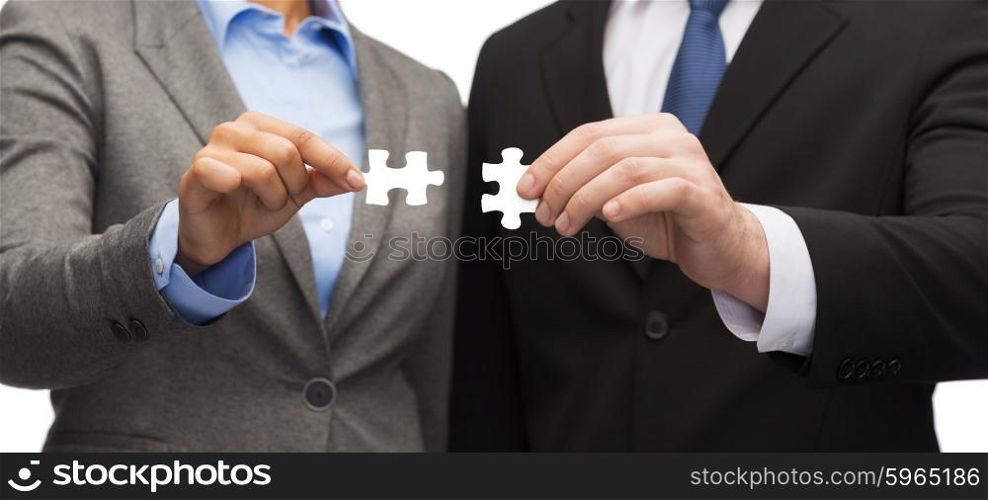 business concept - businessman and businesswoman trying to connect puzzle pieces in office. businessman and businesswoman with puzzle pieces