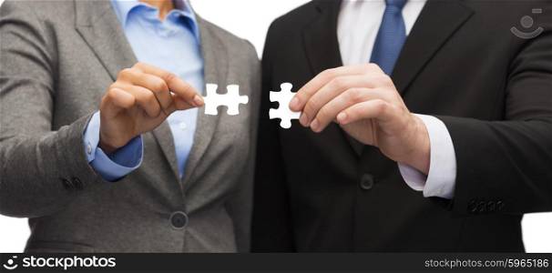business concept - businessman and businesswoman trying to connect puzzle pieces in office. businessman and businesswoman with puzzle pieces