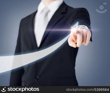 business concept - businessman hand showing raising arrow on virtual screen