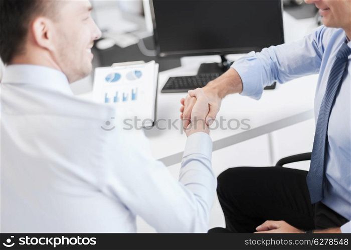 business concept - businessmen shaking hands in office
