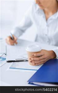 business concept - businesswoman with coffee filling in blank paper