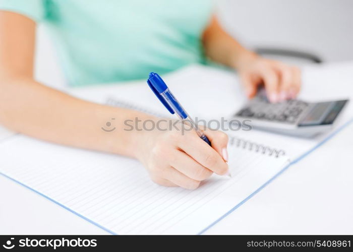 business concept - businesswoman working with calculator in office