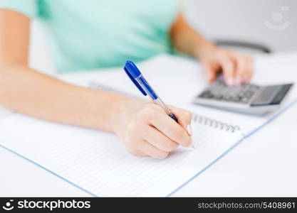 business concept - businesswoman working with calculator in office