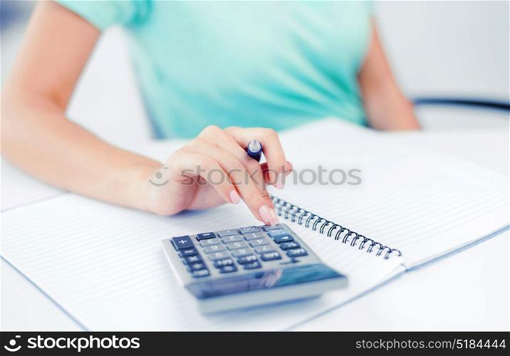 business concept - businesswoman working with calculator in office. businesswoman working with calculator in office