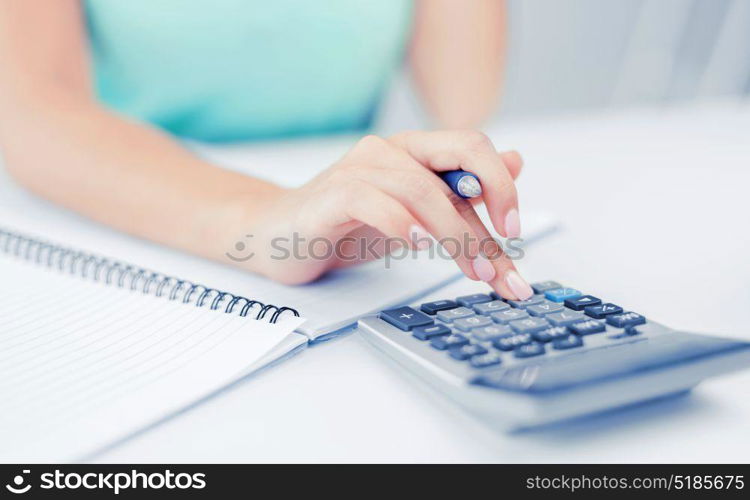 business concept - businesswoman working with calculator in office. businesswoman working with calculator in office