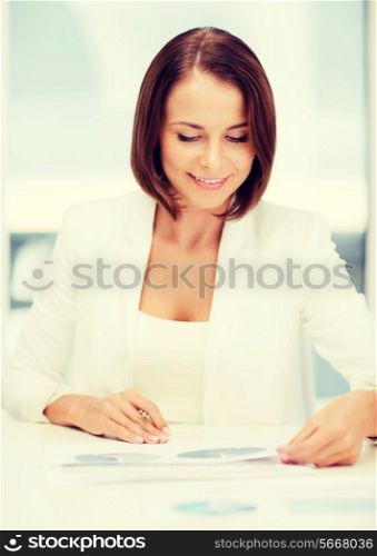 business concept - businesswoman working with graphs in office