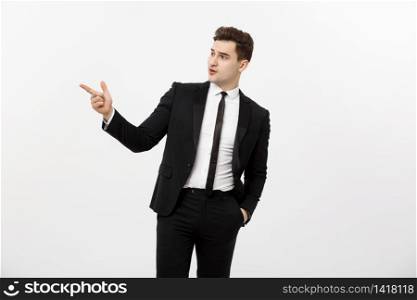 Business Concept: Close up portrait of young successful brunete stock-market broker guy or businessman pointing on a copyspace with his finger on white background. Business Concept: Close up portrait of young successful brunete stock-market broker guy or businessman pointing on a copyspace with his finger on white background.