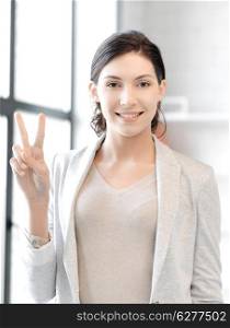 business concept - confident young woman showing v-sign