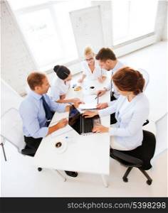 business concept - friendly business team having meeting in office