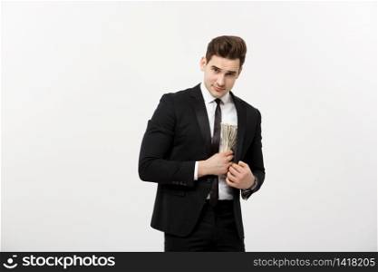 Business Concept: Handsome businessman in black suit taking dollars banknotes with stealthy expression against white background. Business Concept: Handsome businessman in black suit taking dollars banknotes with stealthy expression against white background.