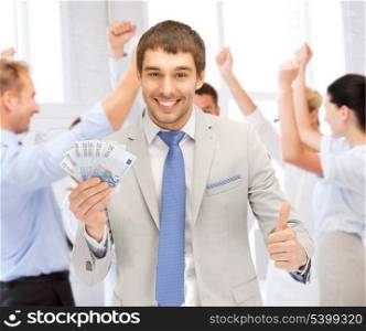 business concept - happy businessman with cash money in office