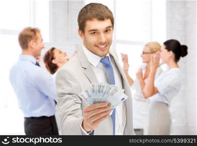 business concept - happy businessman with cash money in office