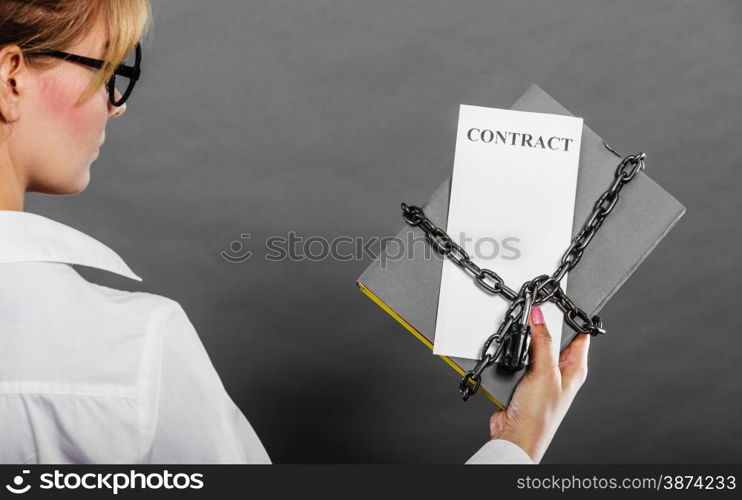 Business concept, limited by contract. Woman holding in hands paper document chained with padlock