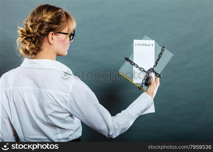 Business concept, limited by contract. Woman holding in hands paper document chained with padlock